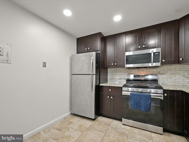 kitchen featuring dark brown cabinetry, backsplash, light stone countertops, and appliances with stainless steel finishes