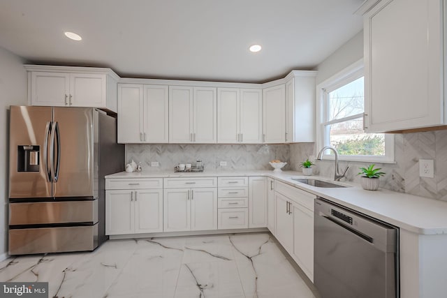 kitchen with white cabinetry, sink, backsplash, and stainless steel appliances