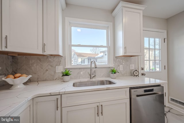 kitchen with sink, dishwasher, backsplash, light stone countertops, and white cabinets