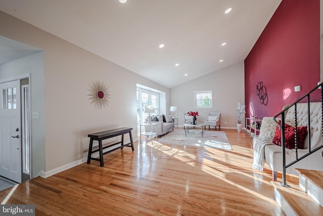 living room featuring high vaulted ceiling and light wood-type flooring