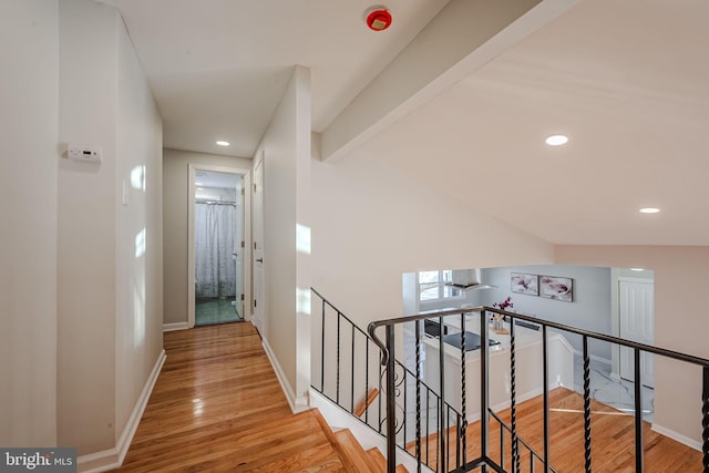 corridor with hardwood / wood-style flooring and beamed ceiling