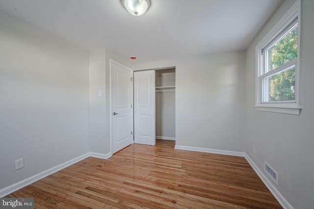 unfurnished bedroom featuring light hardwood / wood-style flooring and a closet