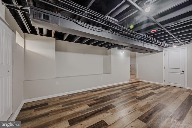 basement with hardwood / wood-style flooring