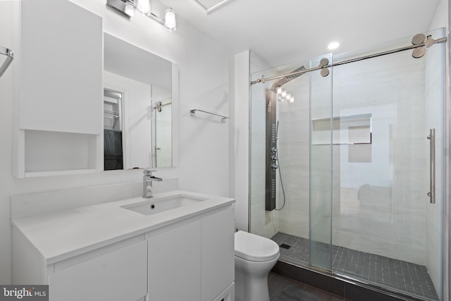 bathroom with vanity, toilet, and a shower with shower door