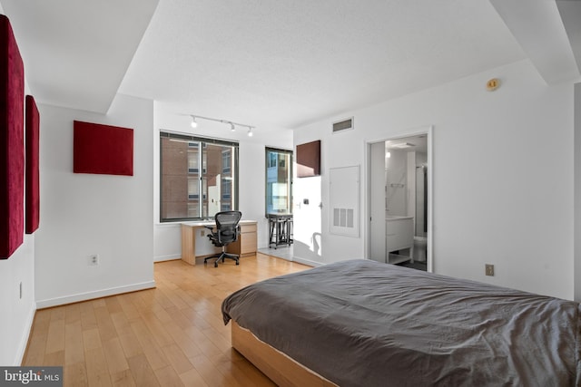 bedroom with hardwood / wood-style flooring and ensuite bathroom