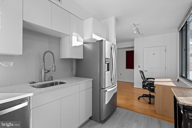 kitchen featuring white cabinetry, appliances with stainless steel finishes, sink, and light wood-type flooring