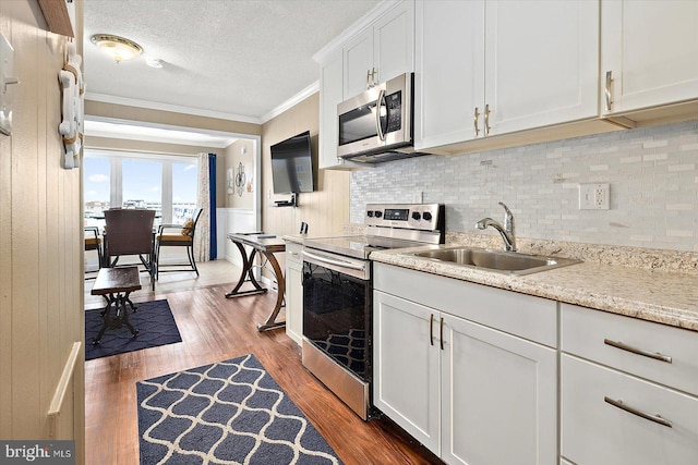 kitchen with sink, a textured ceiling, dark hardwood / wood-style floors, stainless steel appliances, and white cabinets