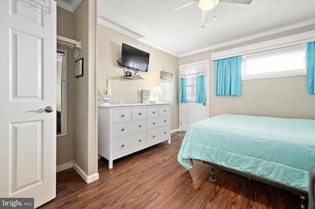 bedroom with ceiling fan, ornamental molding, dark hardwood / wood-style flooring, and a textured ceiling