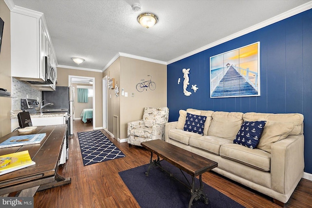 living room with crown molding, dark wood-type flooring, and a textured ceiling