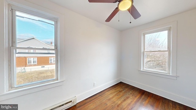 empty room with a baseboard radiator, dark hardwood / wood-style floors, and a wealth of natural light