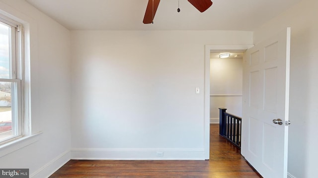 spare room with ceiling fan, a healthy amount of sunlight, and dark hardwood / wood-style floors