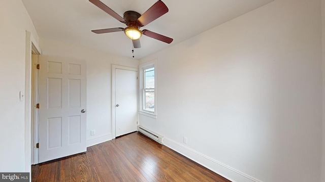 unfurnished bedroom with dark wood-type flooring, a baseboard radiator, and ceiling fan