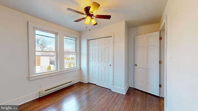 unfurnished bedroom featuring ceiling fan, dark hardwood / wood-style floors, baseboard heating, and a closet