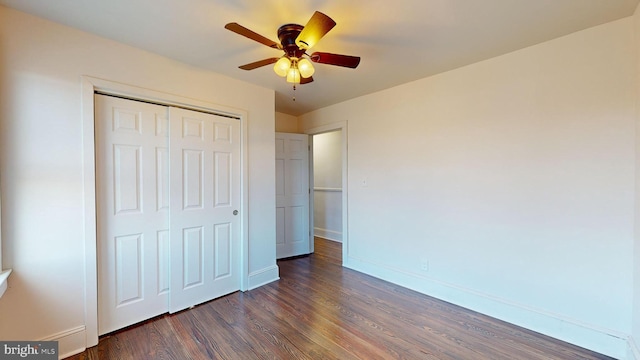 unfurnished bedroom with dark hardwood / wood-style floors, ceiling fan, and a closet