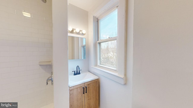 bathroom with vanity and a tile shower