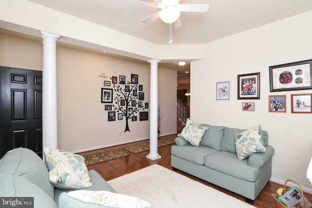 living room with wood-type flooring, decorative columns, and ceiling fan