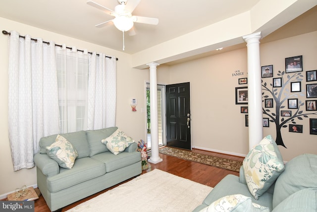 living room featuring wood-type flooring, decorative columns, and ceiling fan