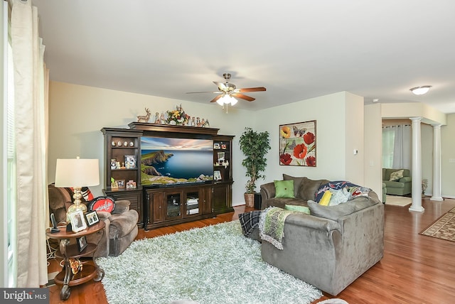 living room with ceiling fan, wood-type flooring, and decorative columns