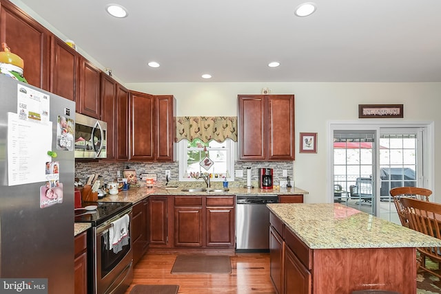 kitchen featuring sink, dark hardwood / wood-style floors, stainless steel appliances, light stone countertops, and backsplash