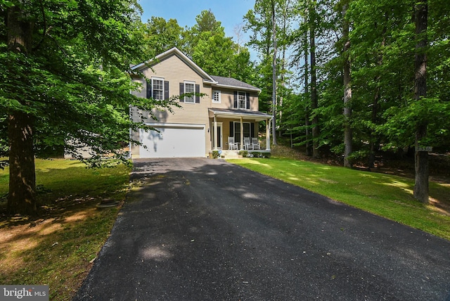 view of front of house with a garage, a front lawn, and covered porch