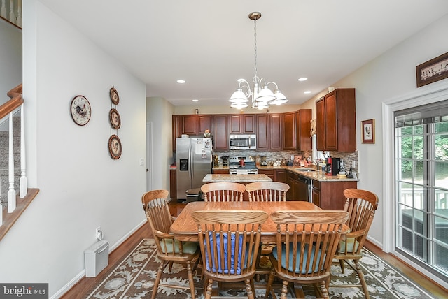 dining space with dark hardwood / wood-style floors, sink, and a notable chandelier