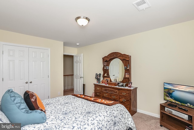 bedroom with light carpet and a closet