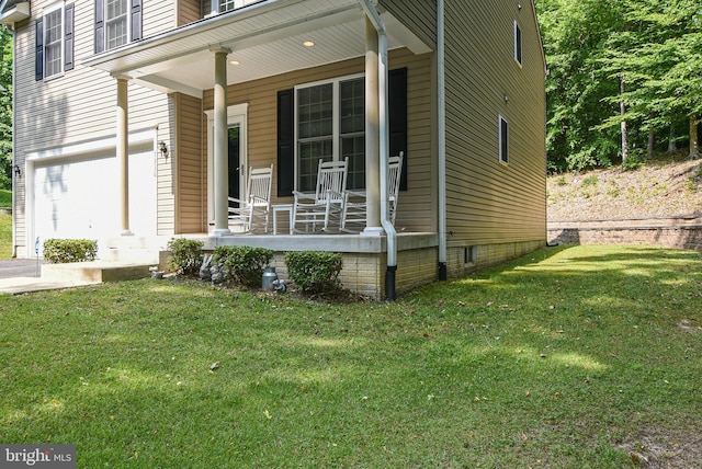 exterior space featuring a garage, covered porch, and a lawn