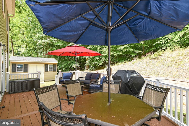 wooden terrace featuring a grill, an outdoor hangout area, and a storage unit