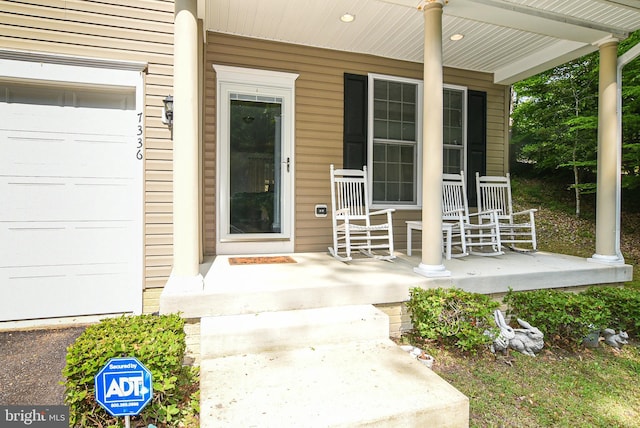 entrance to property featuring a porch and a garage