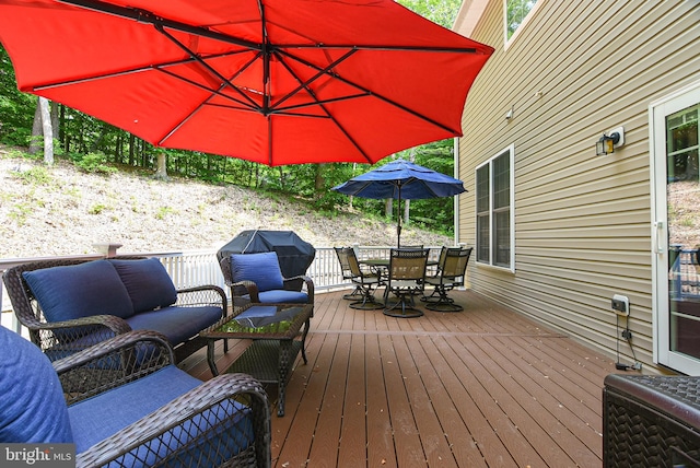 wooden terrace featuring outdoor lounge area and a grill