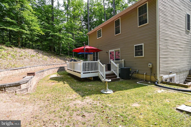 rear view of house featuring a wooden deck, central AC, and a lawn