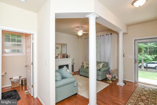 living room featuring hardwood / wood-style flooring, ceiling fan, and ornate columns