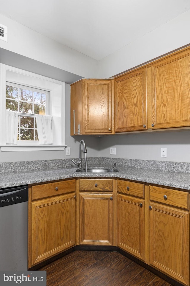 kitchen with sink, stainless steel dishwasher, light stone counters, and dark wood-type flooring