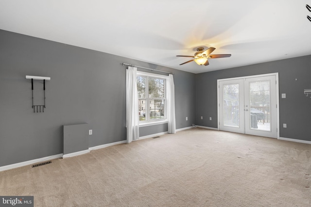 carpeted empty room with ceiling fan and french doors