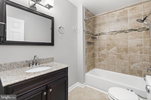 full bathroom featuring tile patterned flooring, vanity, tiled shower / bath, and toilet