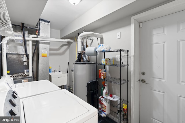 laundry room with sink, washing machine and dryer, and gas water heater