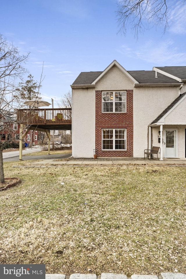 rear view of property with a wooden deck and a yard