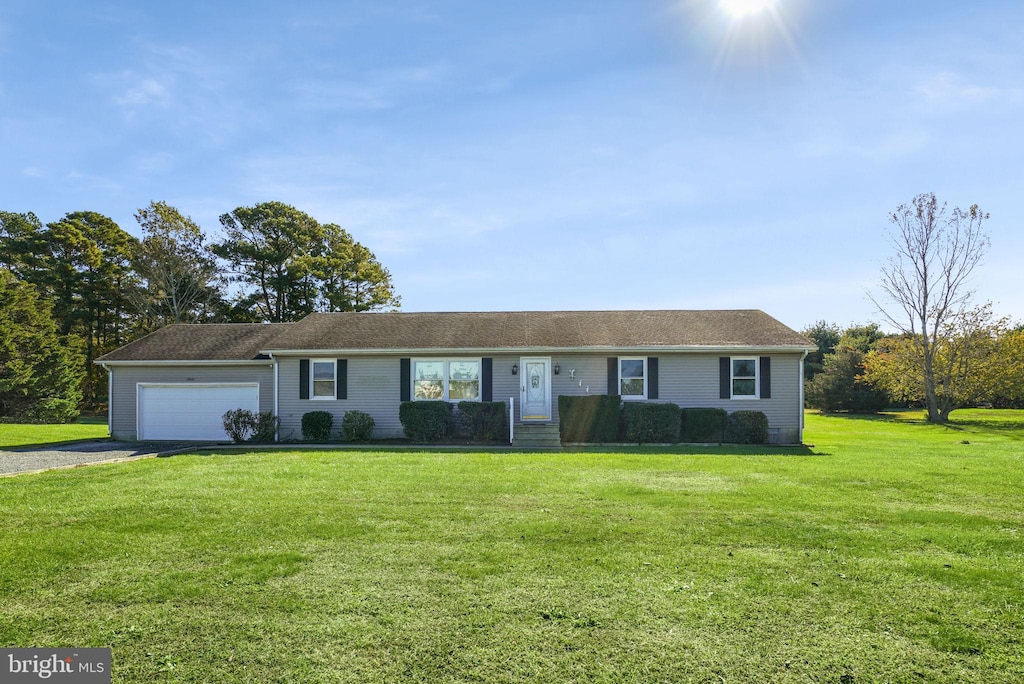 ranch-style house featuring a garage and a front lawn