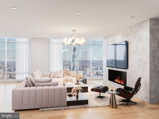 living room featuring a notable chandelier, floor to ceiling windows, and light wood-type flooring