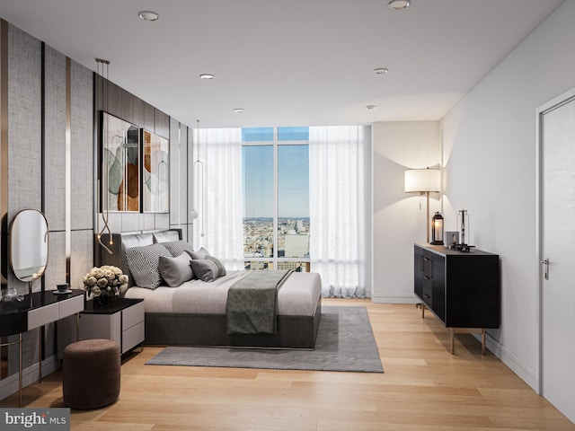 bedroom with expansive windows and light hardwood / wood-style flooring