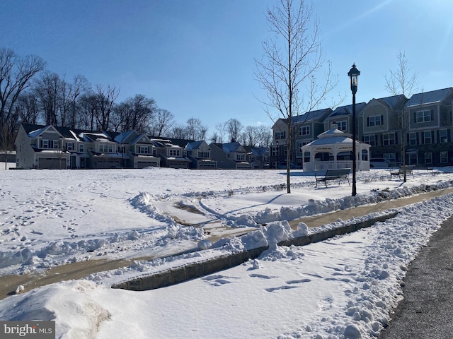 yard layered in snow with a gazebo