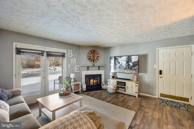 living room with dark hardwood / wood-style floors, a textured ceiling, and french doors