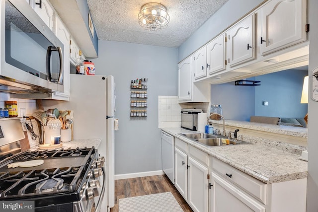 kitchen featuring appliances with stainless steel finishes, sink, white cabinets, and a textured ceiling