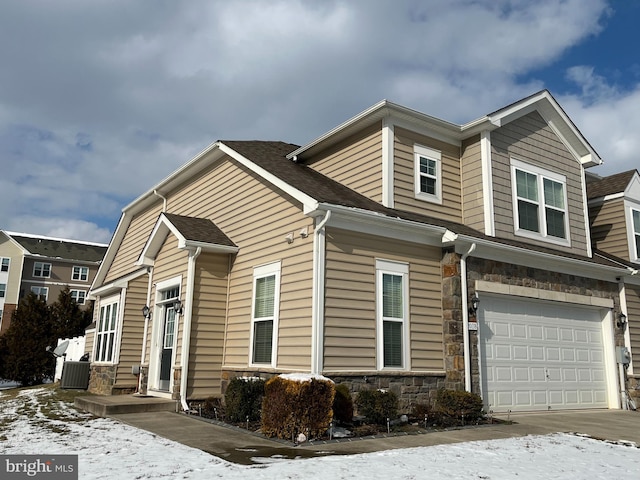 view of front of home with a garage and central AC