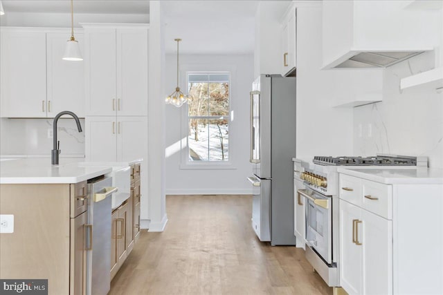 kitchen with white cabinetry, appliances with stainless steel finishes, custom exhaust hood, and pendant lighting