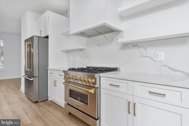 kitchen with tasteful backsplash, premium appliances, light hardwood / wood-style floors, white cabinets, and custom exhaust hood