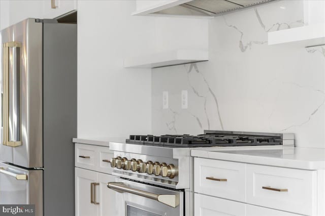 kitchen with white cabinetry, premium appliances, and decorative backsplash