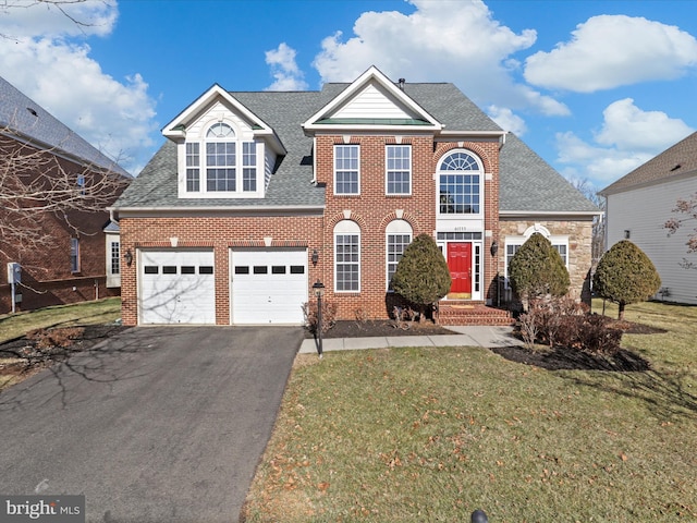 view of property featuring a garage and a front lawn