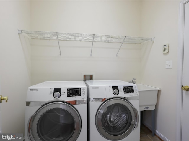 laundry area with washing machine and clothes dryer and dark tile patterned floors