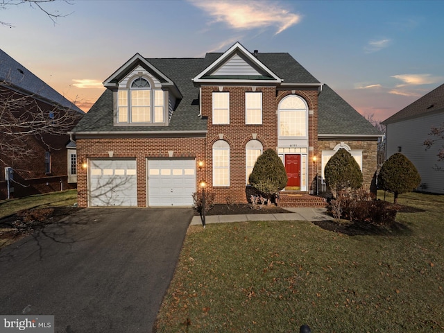 view of property with a garage and a lawn